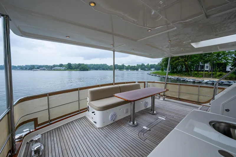 Venture Yacht Photos Pics Spacious deck of 2014 Grand Banks 54 Europa yacht with seating and table, overlooking serene waters.