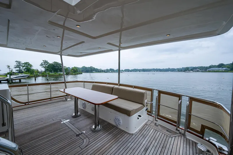 Venture Yacht Photos Pics 2014 Grand Banks 54 Europa yacht deck with seating and table, overlooking serene waters.
