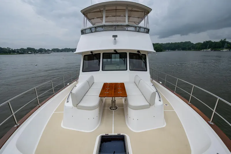 Venture Yacht Photos Pics 2014 Grand Banks 54 Europa yacht with spacious deck seating and table on a calm waterway.