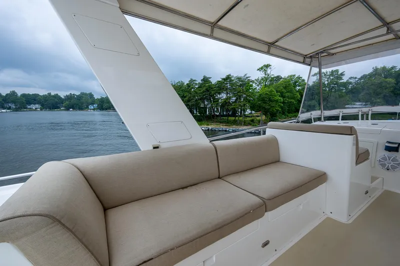 Venture Yacht Photos Pics 2014 Grand Banks 54 Europa yacht with spacious outdoor seating, overlooking serene waters and lush greenery.