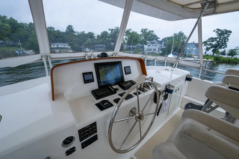 Venture Yacht Photos Pics Helm of 2014 Grand Banks 54 Europa yacht with navigation equipment and scenic waterfront view.