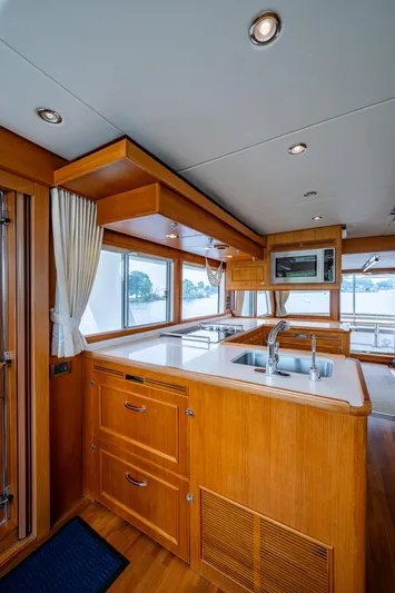 Venture Yacht Photos Pics Luxurious kitchen interior of 2014 Grand Banks 54 Europa yacht with wooden cabinetry.