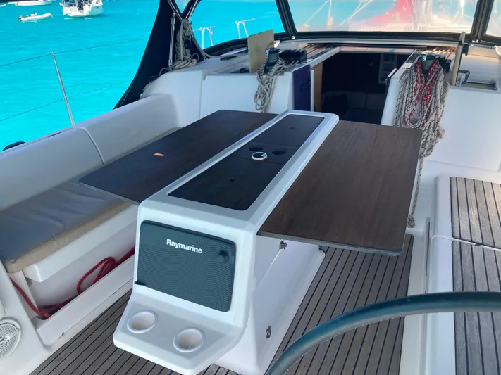 Caff&Eacute; Latte Yacht Photos Pics Dufour 410 Grand Large 2013 yacht cockpit with table and seating, overlooking turquoise water.