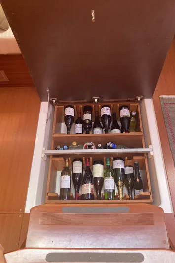 Caff&Eacute; Latte Yacht Photos Pics Wine storage compartment on a 2013 Dufour 410 Grand Large yacht, featuring various bottles.