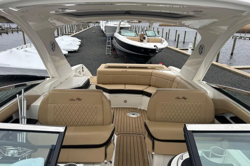  Yacht Photos Pics 2021 Sea Ray SLX 310 boat interior with tan seating at a marina.