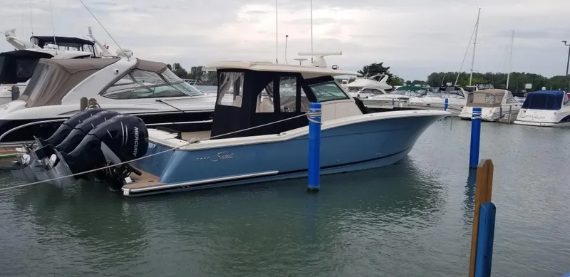  Yacht Photos Pics 2018 Scout 380 LXF boat docked in marina, featuring sleek design and multiple engines.