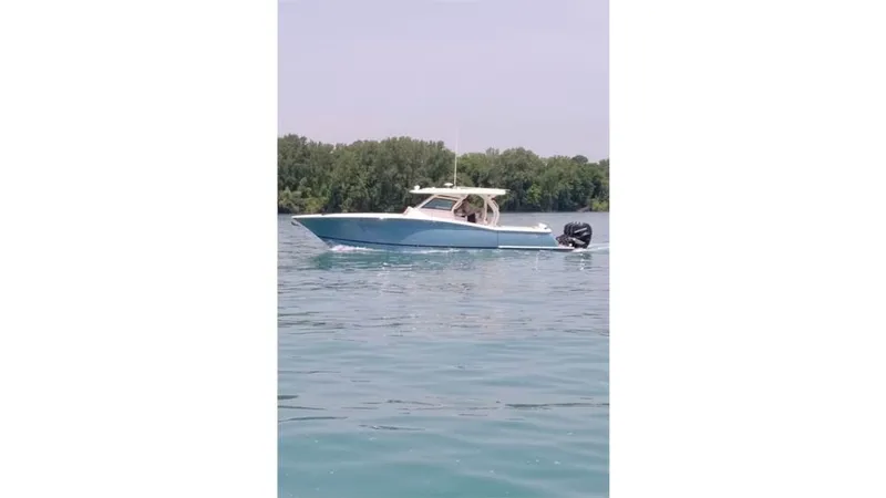  Yacht Photos Pics 2018 Scout 380 LXF boat on calm water with trees in background.