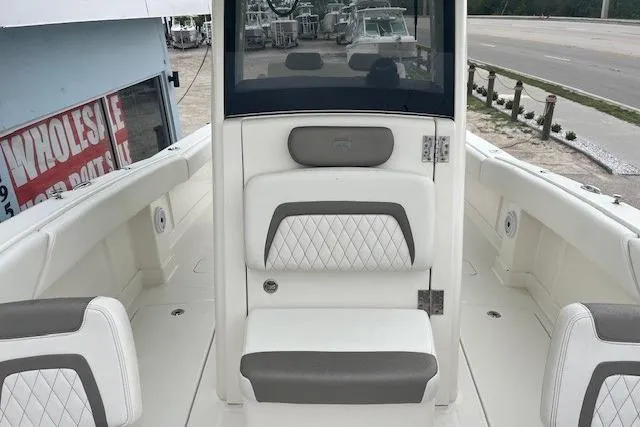  Yacht Photos Pics 2023 World Cat 280 CC-X boat interior with white and gray seating, docked near a dealership.