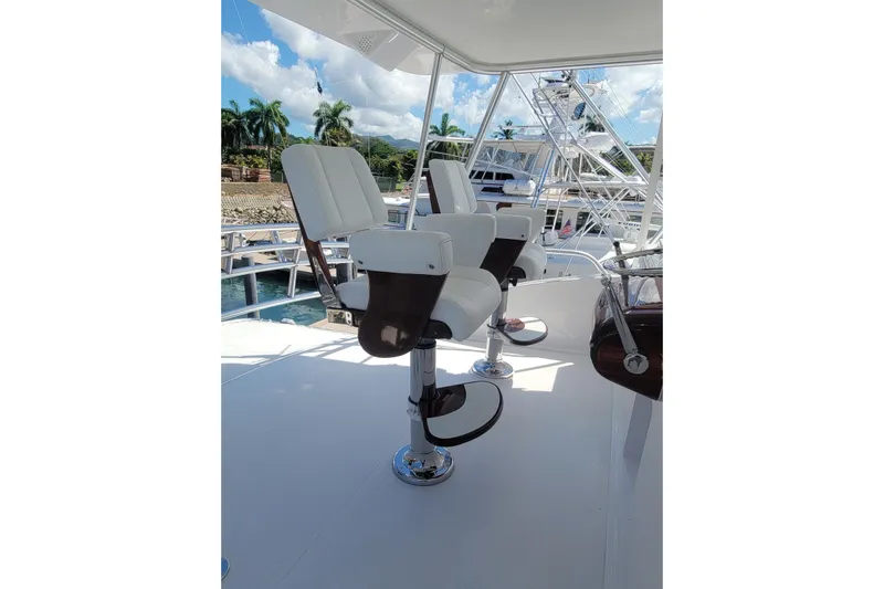  Yacht Photos Pics Luxury seating on 2012 Viking 64c yacht, featuring sleek white chairs and ocean backdrop.