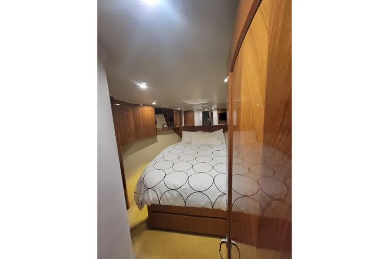  Yacht Photos Pics Luxurious bedroom interior of 2012 Viking 64c yacht with elegant wood paneling.