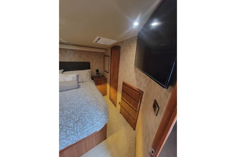  Yacht Photos Pics Luxurious bedroom interior of 2012 Viking 64c yacht with modern decor and wall-mounted TV.
