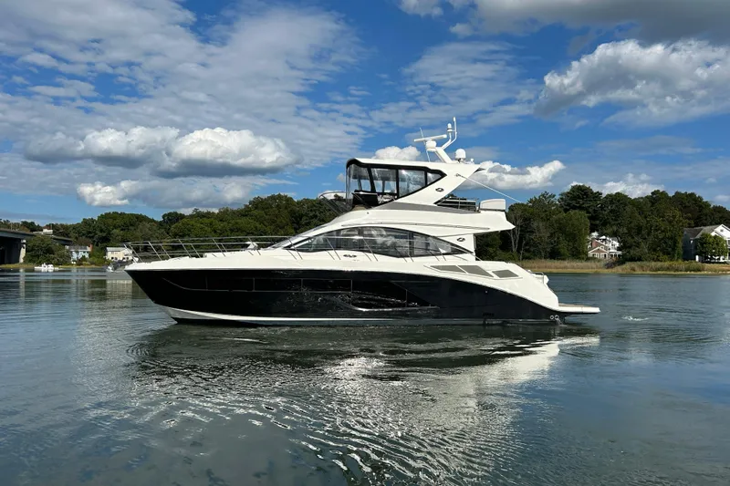  Yacht Photos Pics 2018 Sea Ray Fly 520 yacht cruising on a calm lake under a blue sky.