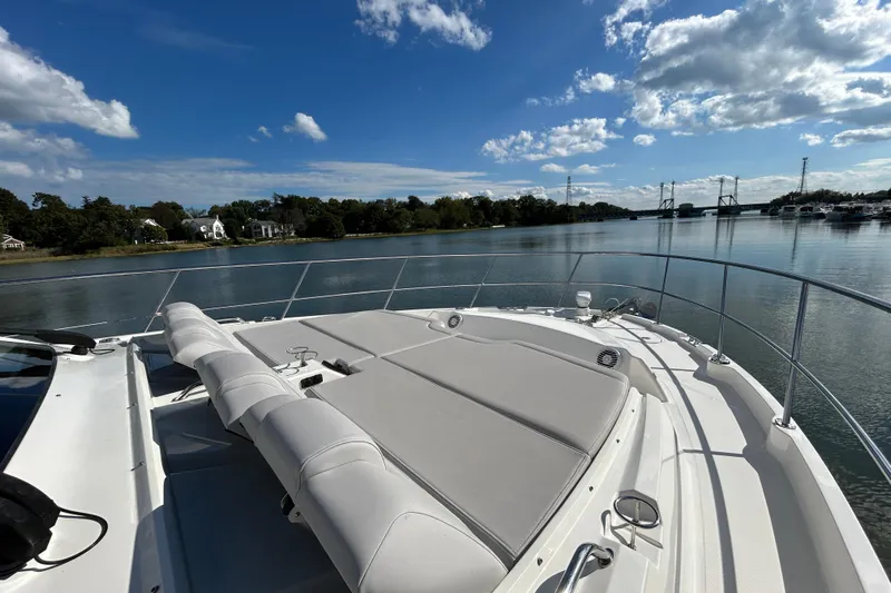  Yacht Photos Pics 2018 Sea Ray Fly 520 yacht with spacious deck, cruising on a serene river under a blue sky.