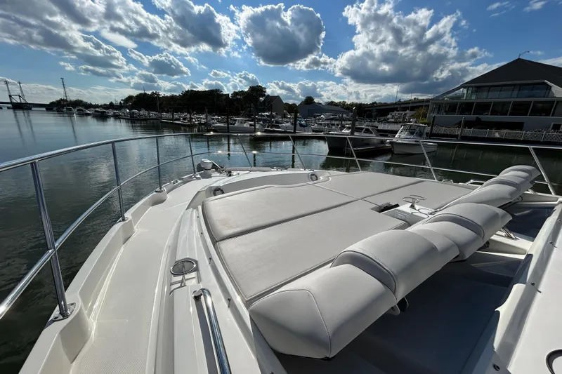  Yacht Photos Pics 2018 Sea Ray Fly 520 yacht with sun deck, docked in a marina under a cloudy sky.