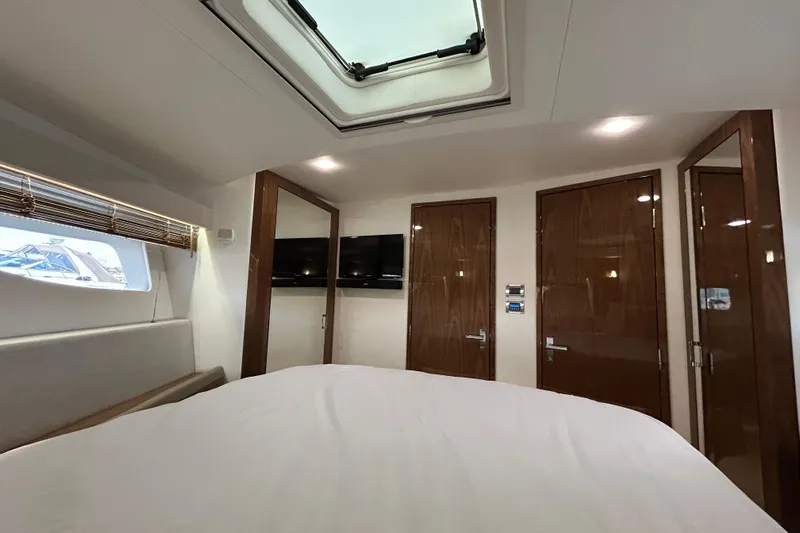  Yacht Photos Pics Luxurious interior of 2018 Sea Ray Fly 520 yacht cabin with skylight and wooden finishes.