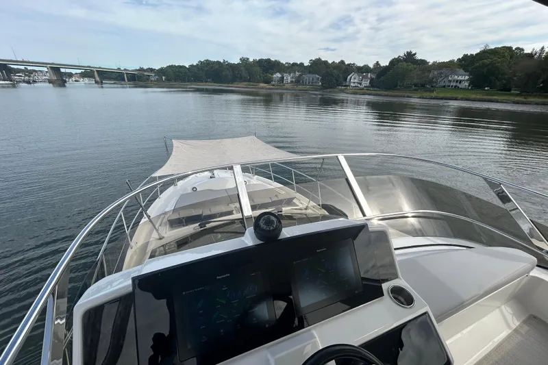  Yacht Photos Pics 2018 Sea Ray Fly 520 yacht navigating calm waters near a scenic shoreline.