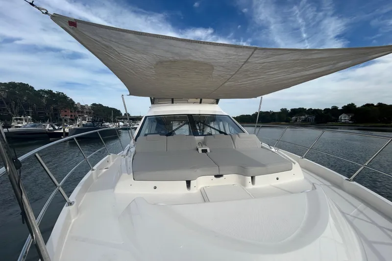  Yacht Photos Pics 2018 Sea Ray Fly 520 yacht with sunshade, docked in a serene marina setting.