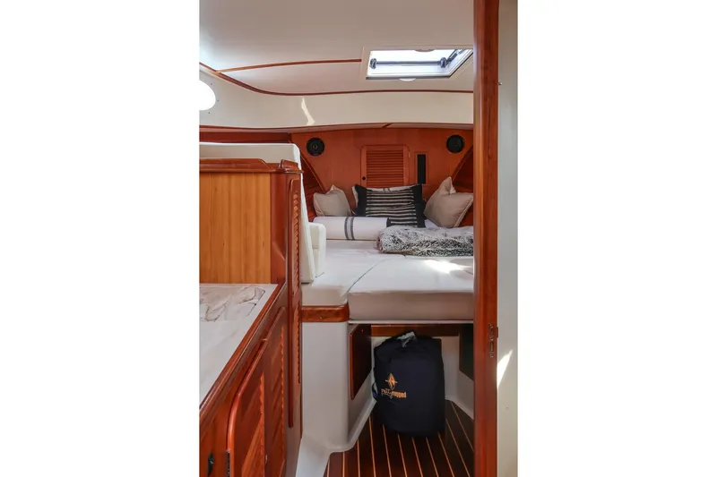 Bristol Yacht Photos Pics 2015 Hinckley Picnic Boat 37 MKIII cabin interior with cozy bedding and wooden finishes.