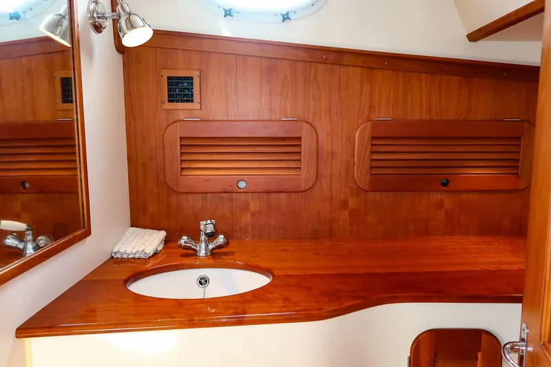 Bristol Yacht Photos Pics Luxurious wooden bathroom interior of 2015 Hinckley Picnic Boat 37 MKIII with sink and mirror.