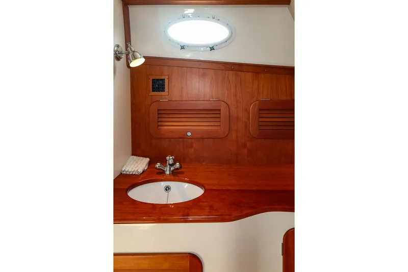 Bristol Yacht Photos Pics 2015 Hinckley Picnic Boat 37 MKIII bathroom with wooden cabinetry and round sink.