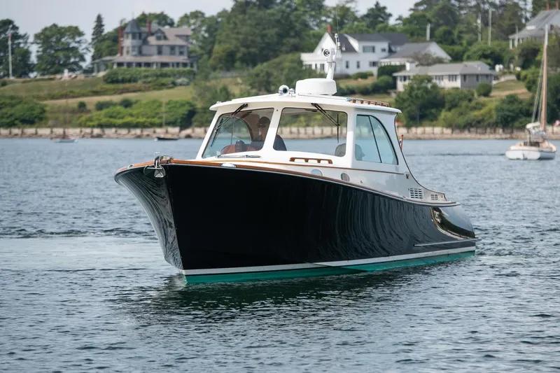 Bristol Yacht Photos Pics 2015 Hinckley Picnic Boat 37 MKIII cruising on calm waters near shoreline homes.