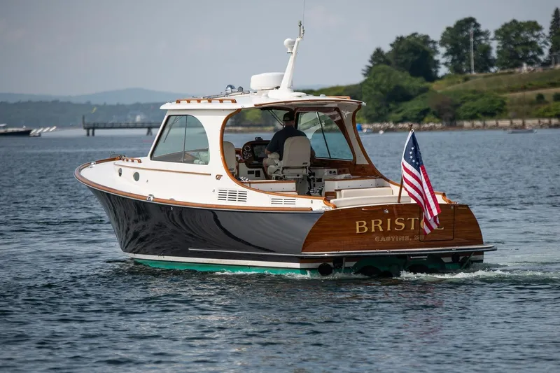 Bristol Yacht Photos Pics 2015 Hinckley Picnic Boat 37 MKIII cruising on a scenic waterway with American flag.