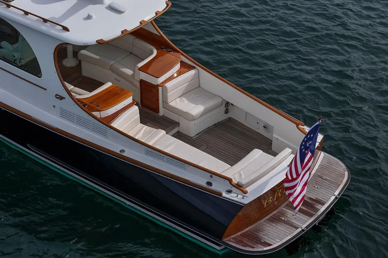 Bristol Yacht Photos Pics 2015 Hinckley Picnic Boat 37 MKIII with elegant seating and American flag on water.