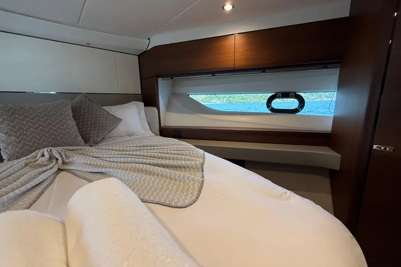 Lariel Yacht Photos Pics Luxurious bedroom interior of 2020 Princess F55 yacht with elegant bedding and scenic window view.