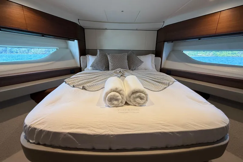 Lariel Yacht Photos Pics Luxurious bedroom interior of 2020 Princess F55 yacht with elegant bedding and scenic windows.