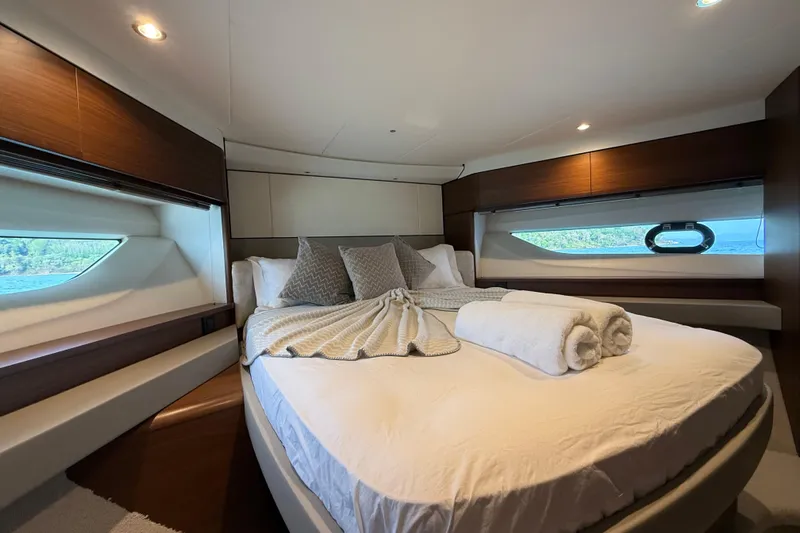 Lariel Yacht Photos Pics Luxurious bedroom interior of 2020 Princess F55 yacht with elegant bedding and scenic window views.