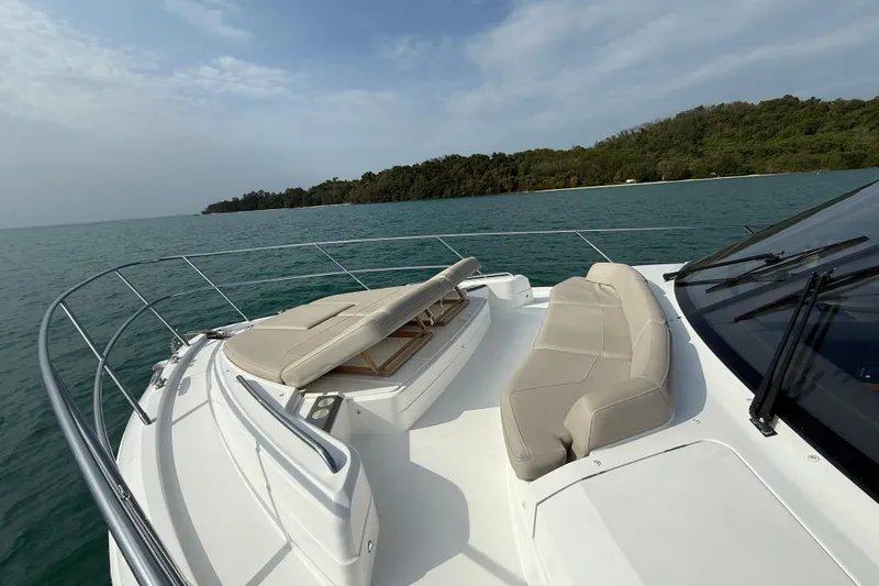 Lariel Yacht Photos Pics Luxurious 2020 Princess F55 yacht with elegant seating, cruising near a lush coastline.