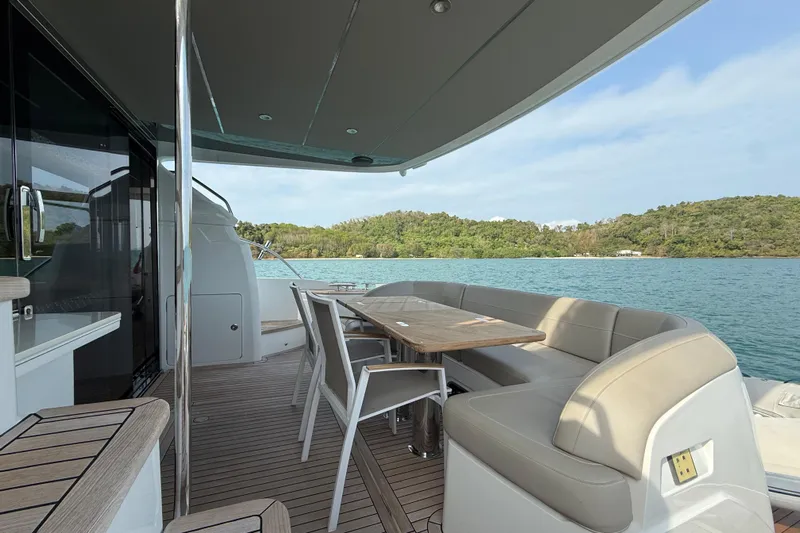 Lariel Yacht Photos Pics Luxurious 2020 Princess F55 yacht deck with seating, overlooking serene waters and lush greenery.