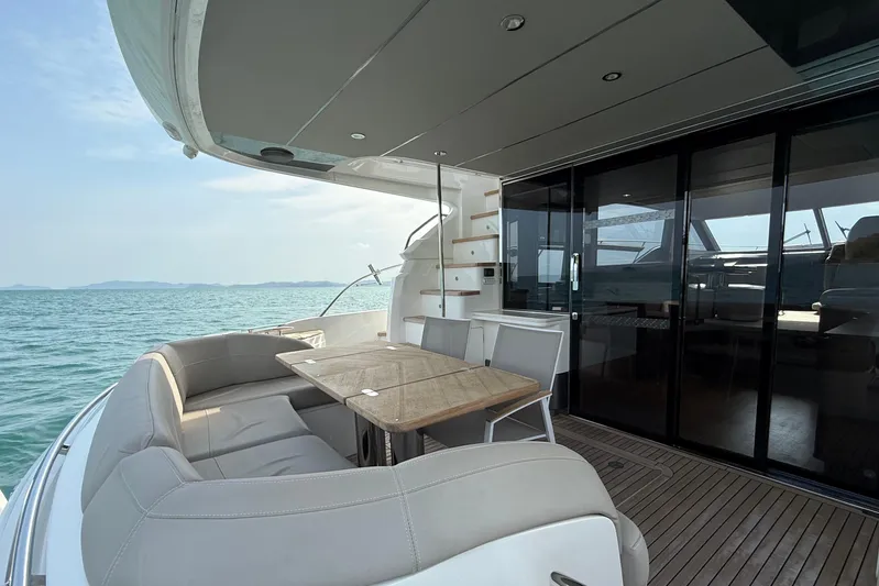 Lariel Yacht Photos Pics Luxurious 2020 Princess F55 yacht deck with seating, table, and ocean view.