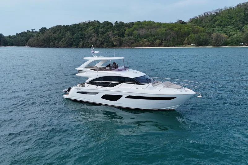 Lariel Yacht Photos Pics Luxurious 2020 Princess F55 yacht cruising on serene blue waters near a lush green coastline.