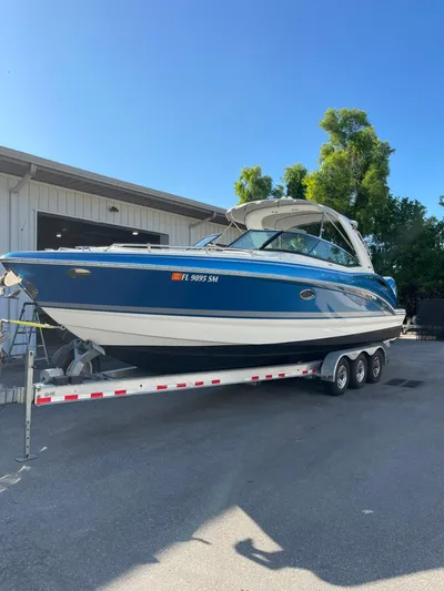  Yacht Photos Pics 2020 Formula 310 Bowrider boat on trailer, parked outdoors under clear blue sky.