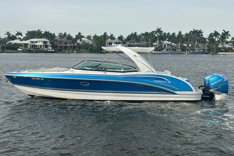  Yacht Photos Pics 2020 Formula 310 Bowrider boat with blue exterior on a calm lake.