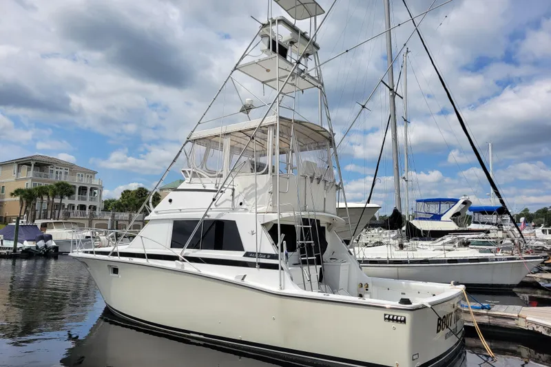 Bout Time Yacht Photos Pics 1979 Bertram 38 Convertible yacht docked at marina under cloudy sky.