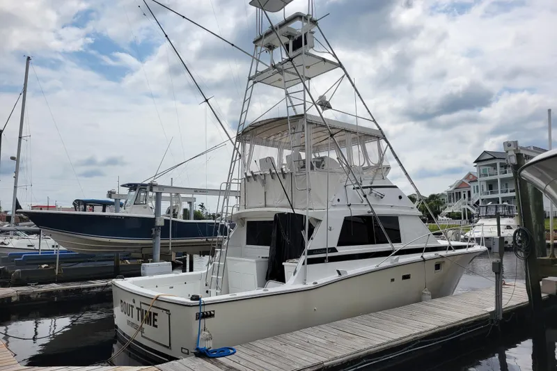 Bout Time Yacht Photos Pics 1979 Bertram 38 Convertible yacht docked at marina under cloudy sky.