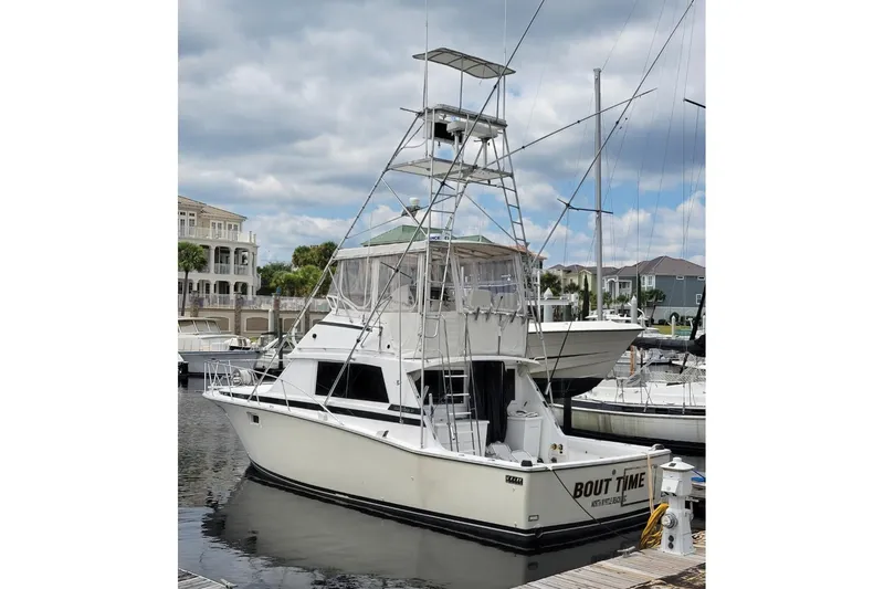 Bout Time Yacht Photos Pics 1979 Bertram 38 Convertible yacht docked at marina under cloudy sky.