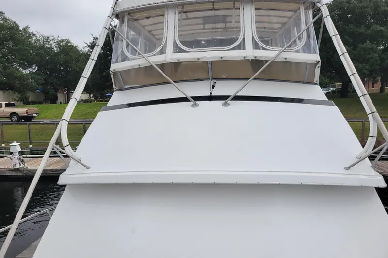 Bout Time Yacht Photos Pics 1979 Bertram 38 Convertible boat docked, front view with enclosed flybridge.
