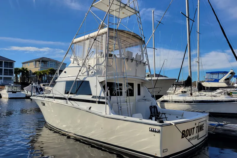 Bout Time Yacht Photos Pics 1979 Bertram 38 Convertible yacht docked in marina under clear blue sky.