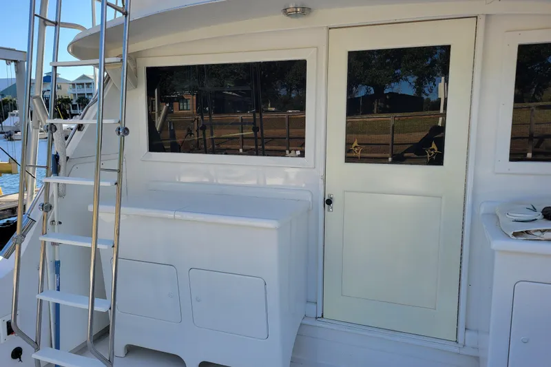 Bout Time Yacht Photos Pics 1979 Bertram 38 Convertible yacht with ladder and cabin door, docked at marina.