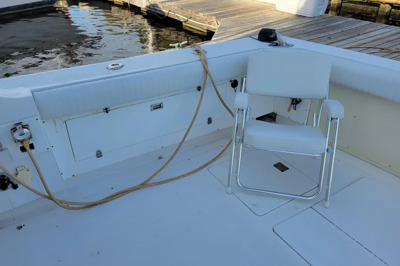 Bout Time Yacht Photos Pics 1979 Bertram 38 Convertible boat deck with white chair and dock view.