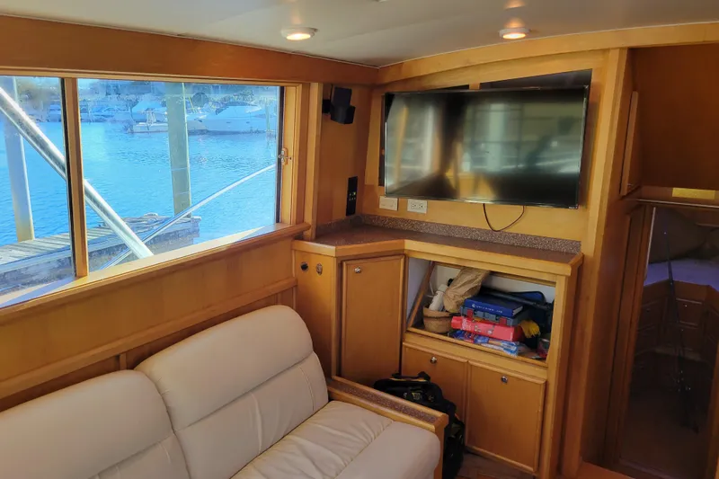 Bout Time Yacht Photos Pics 1979 Bertram 38 Convertible yacht interior with TV, sofa, and marina view.