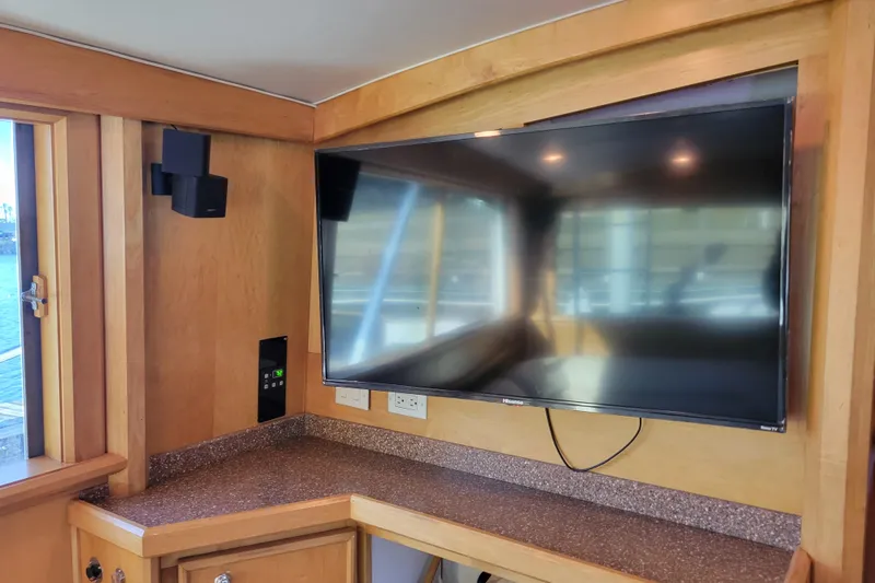 Bout Time Yacht Photos Pics Interior of 1979 Bertram 38 Convertible with mounted TV and wooden cabinetry.