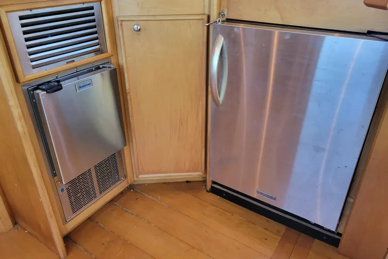 Bout Time Yacht Photos Pics 1979 Bertram 38 Convertible interior with stainless steel appliances and wooden cabinetry.