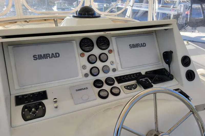 Bout Time Yacht Photos Pics 1979 Bertram 38 Convertible boat dashboard with Simrad navigation equipment and steering wheel.
