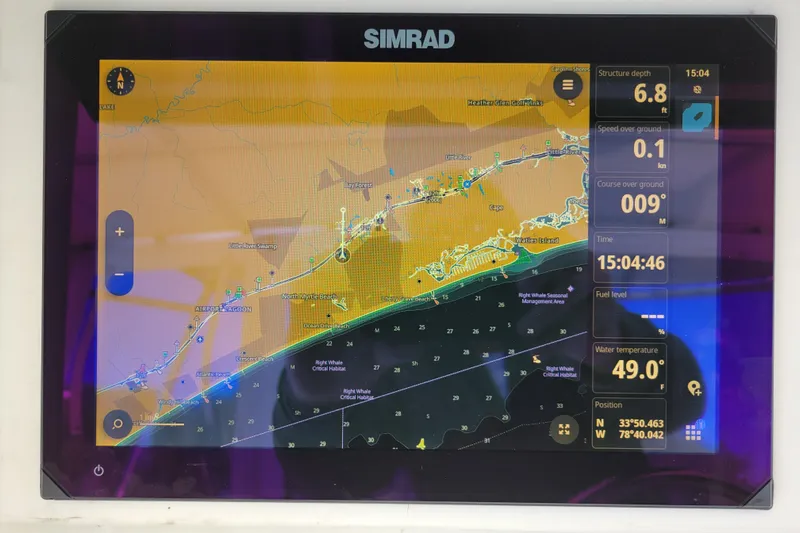 Bout Time Yacht Photos Pics Simrad navigation display on a 1979 Bertram 38 Convertible boat, showing coastal map and data.