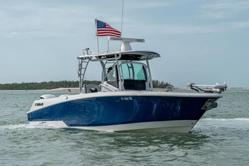  Yacht Photos Pics 2020 Wellcraft 302 Fisherman boat cruising on water with American flag.