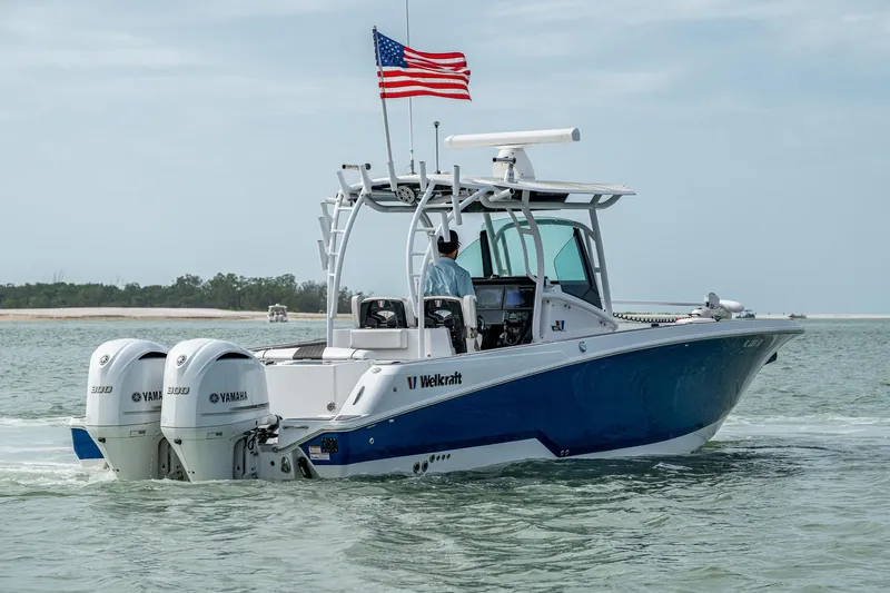  Yacht Photos Pics 2020 Wellcraft 302 Fisherman boat with dual Yamaha engines on the water, American flag flying.